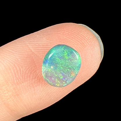 A loose, 1.26 carat semi-black opal stone from Lightning Ridge, Australia.  The opal is green and blue.