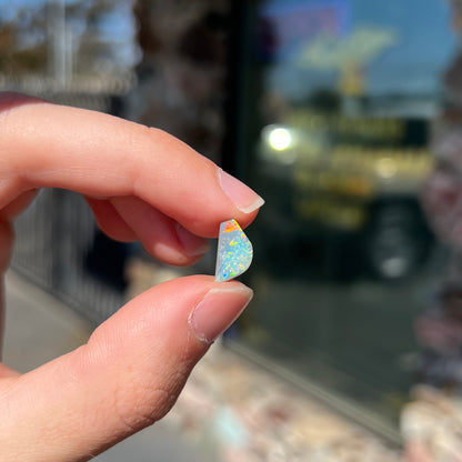 A freeform shaped semi-black opal from Lightning Ridge, Australia that weighs 1.31 carats.