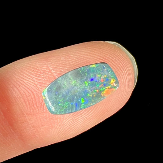 A loose 1.76ct barrel shaped black opal stone from Lightning Ridge, Australia.  The opal has a rainbow of colors.