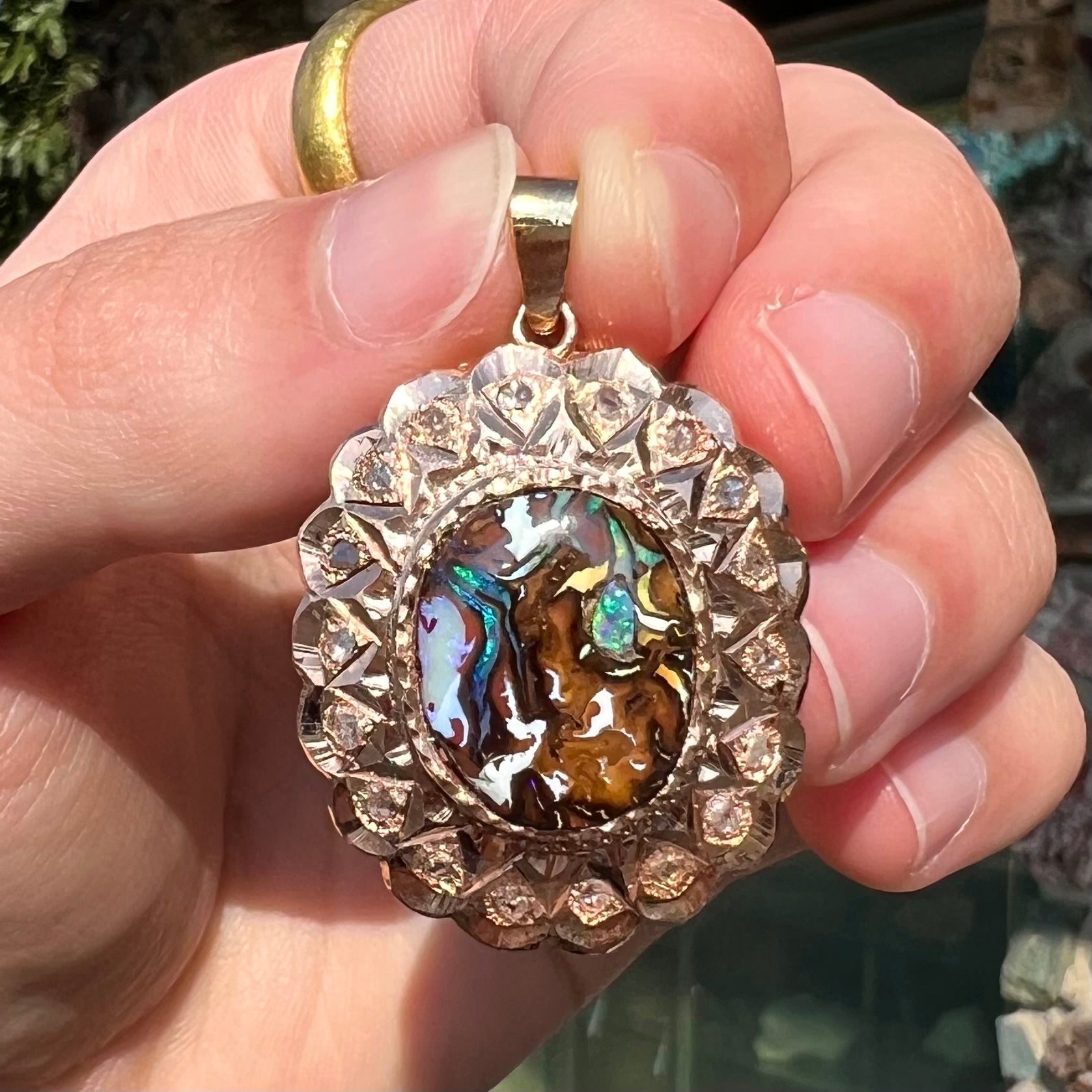 An antique 18 karat yellow gold pendant set with rough diamonds and an oval cut boulder opal from Koroit, Australia.