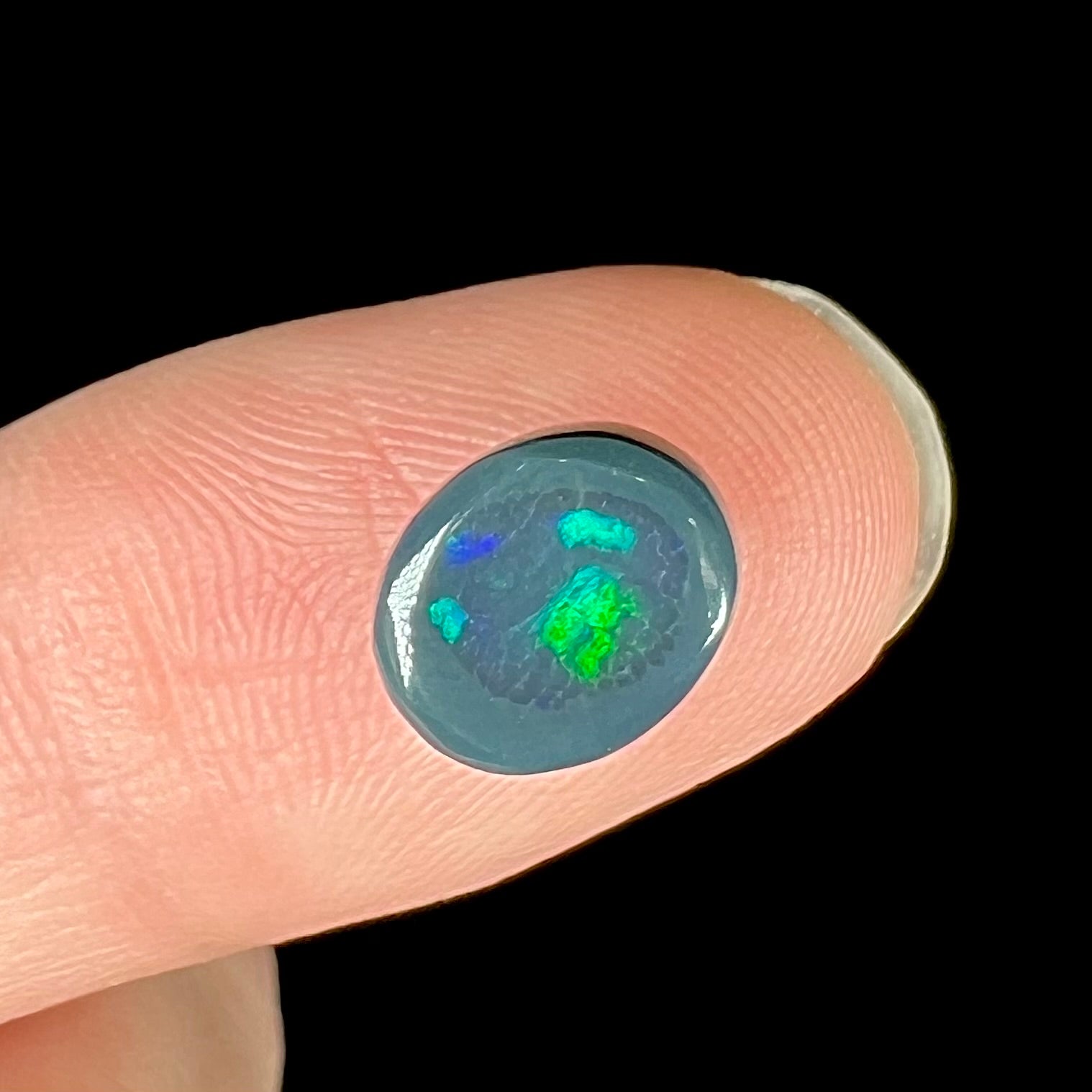 A 2.68 carat loose, oval cabochon cut black opal stone from Lightning Ridge, Australia.  The opal has a N2 body tone.