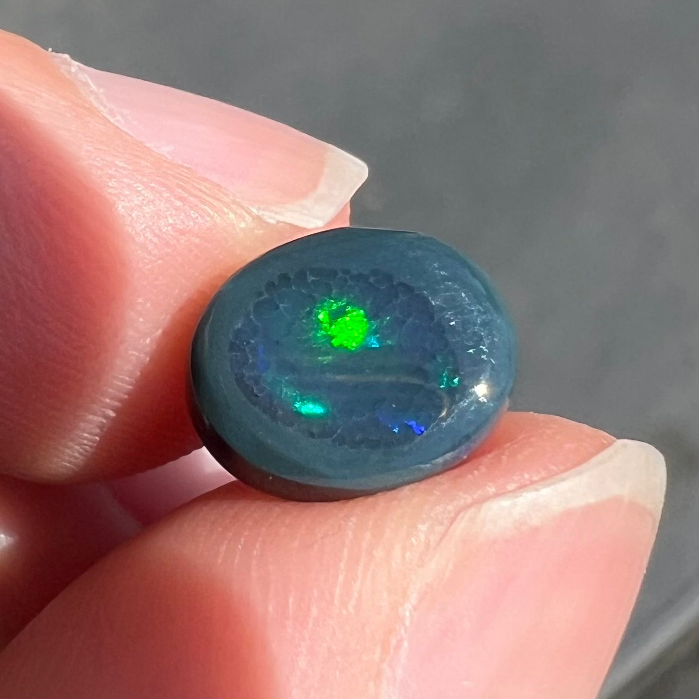 A 2.68 carat loose, oval cabochon cut black opal stone from Lightning Ridge, Australia.  The opal has a N2 body tone.