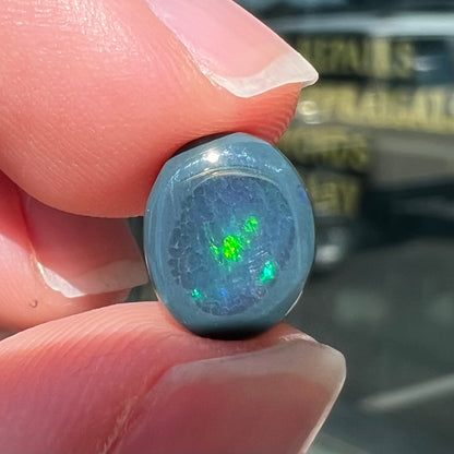 A 2.68 carat loose, oval cabochon cut black opal stone from Lightning Ridge, Australia.  The opal has a N2 body tone.