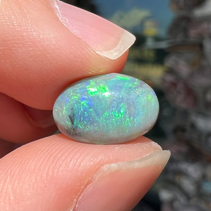 An oval cabochon cut 2.75ct semi-black opal gemstone from Lightning Ridge, Australia.