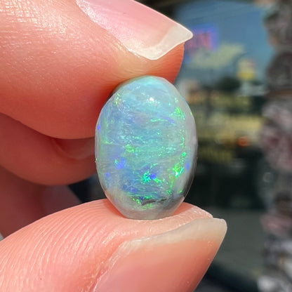 An oval cabochon cut 2.75ct semi-black opal gemstone from Lightning Ridge, Australia.