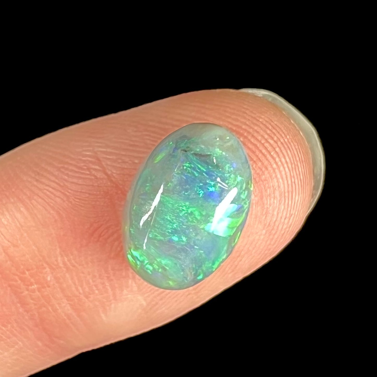 An oval cabochon cut 2.75ct semi-black opal gemstone from Lightning Ridge, Australia.