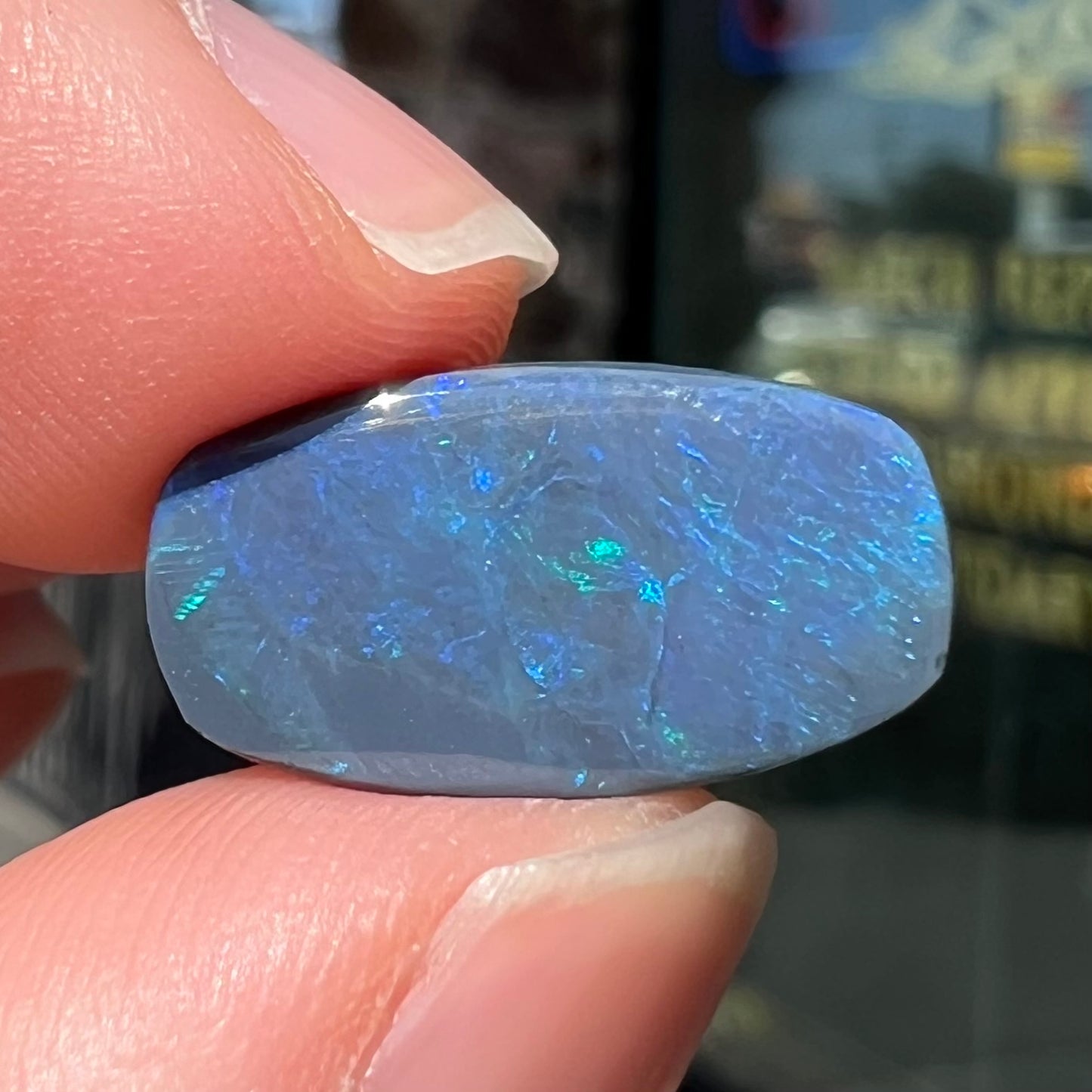 A loose, barrel shaped black opal stone from Lightning Ridge, Australia that weighs 5.25 carats.