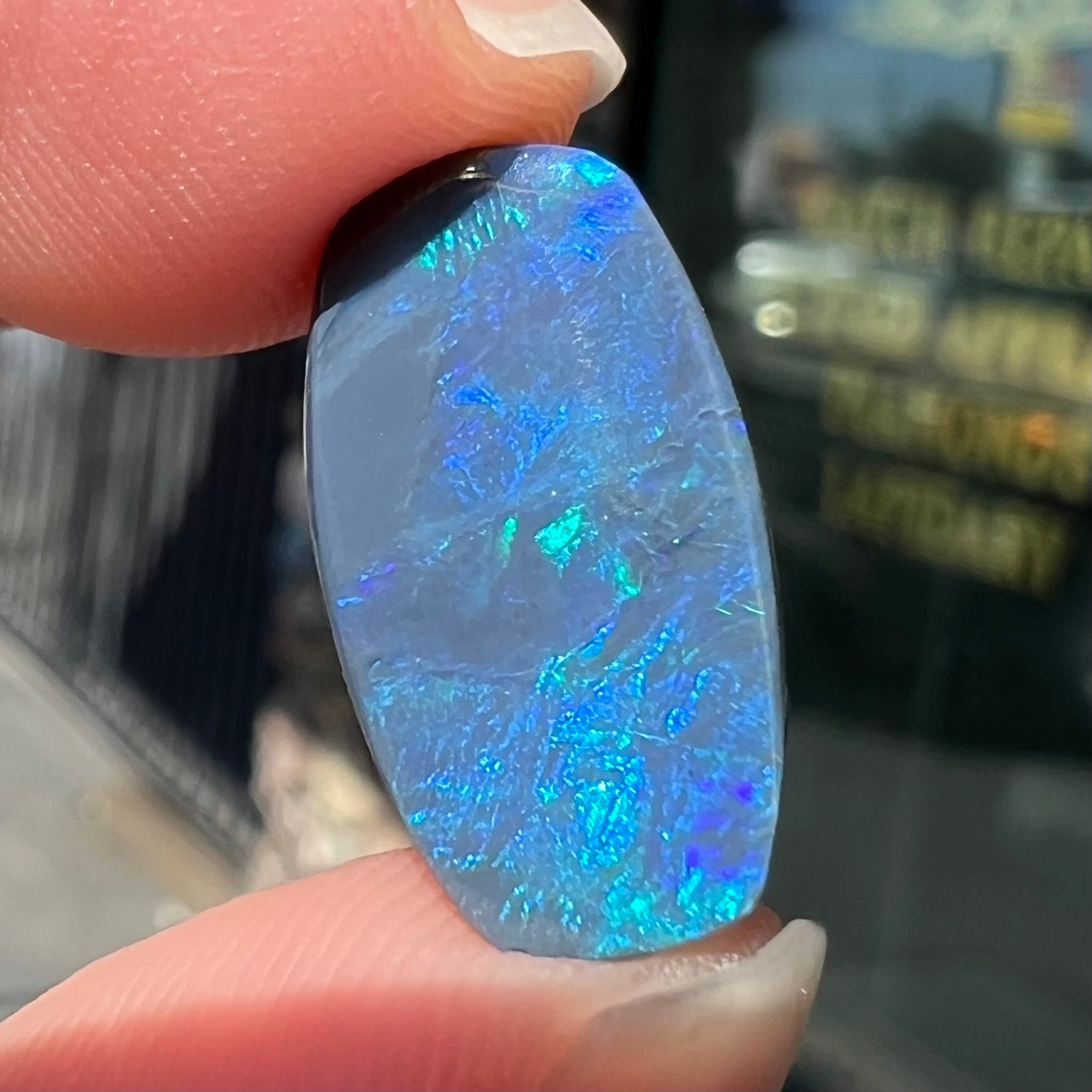 A loose, barrel shaped black opal stone from Lightning Ridge, Australia that weighs 5.25 carats.