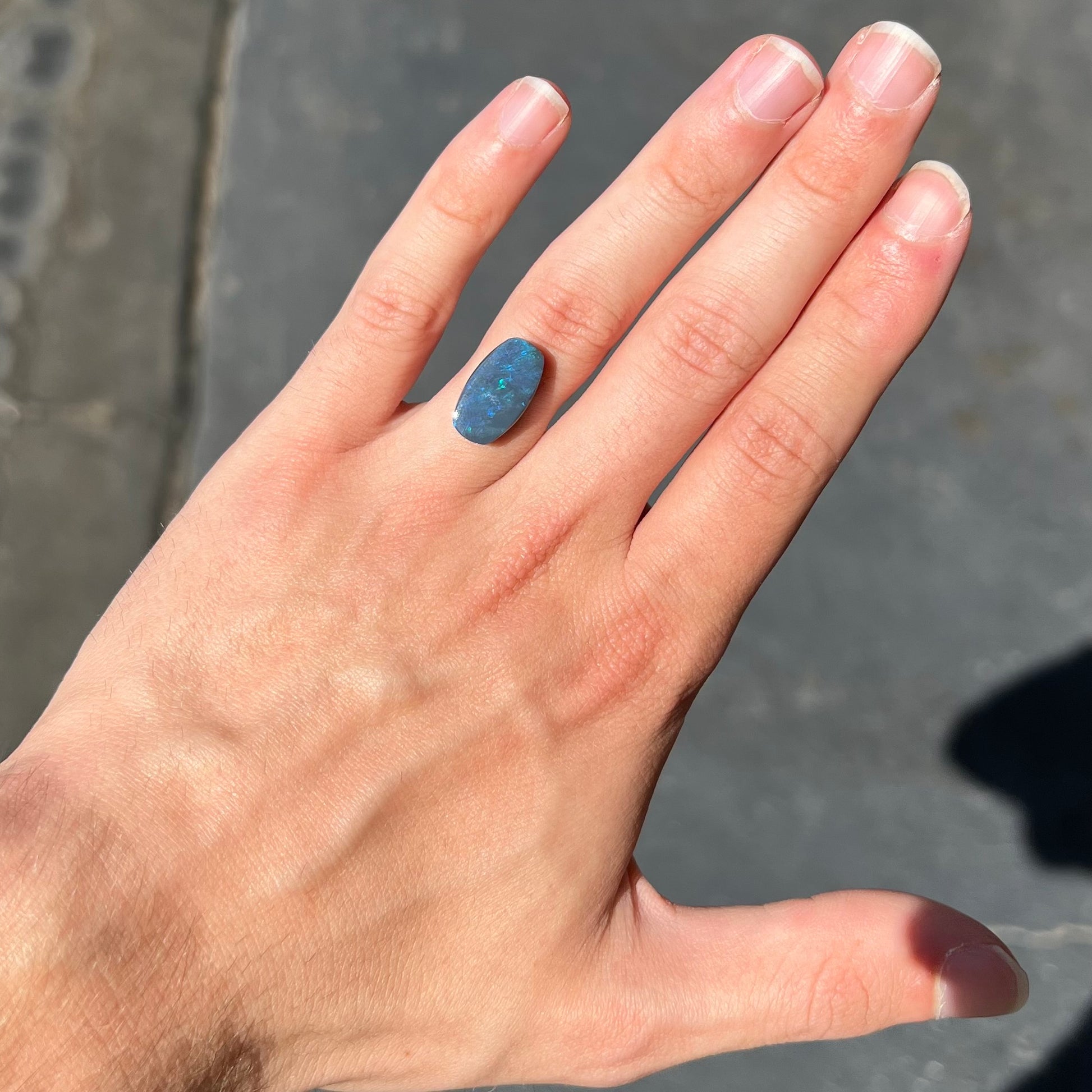 A loose, barrel shaped black opal stone from Lightning Ridge, Australia that weighs 5.25 carats.