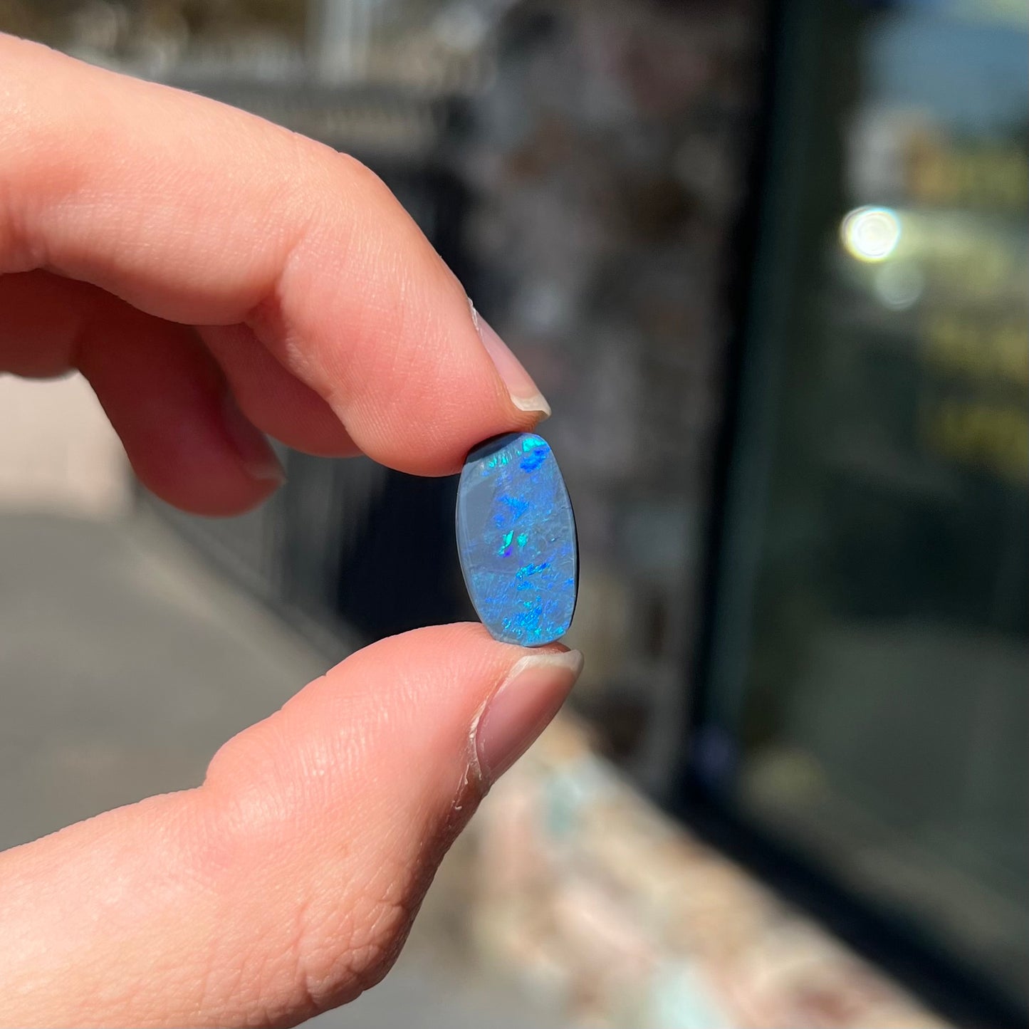 A loose, barrel shaped black opal stone from Lightning Ridge, Australia that weighs 5.25 carats.