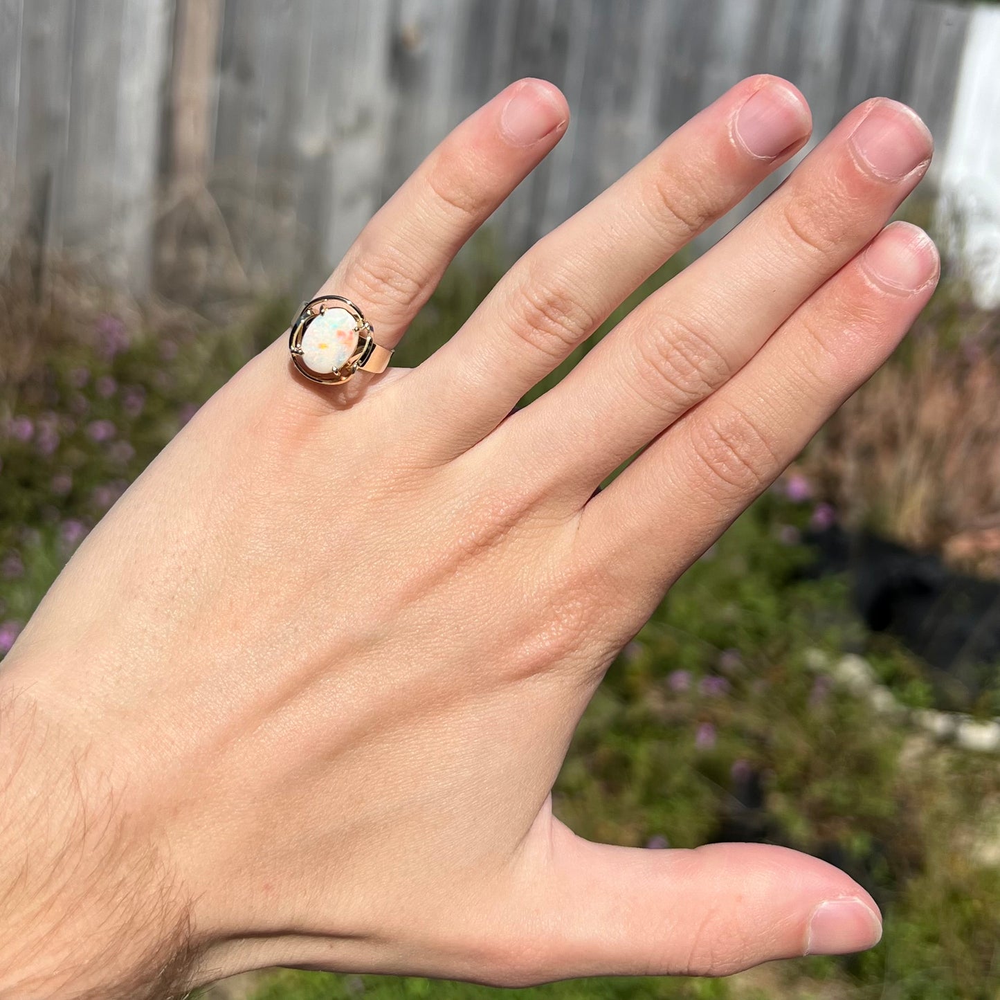 A yellow gold solitaire ring mounted with an oval cut Australian white opal.