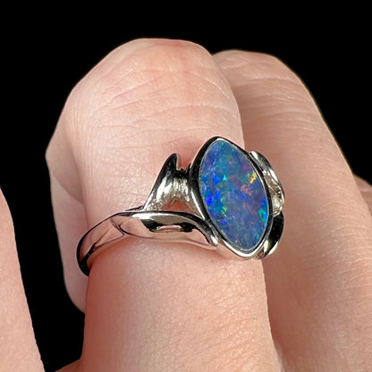 A sterling silver ring mounted with a marquise cut black opal doublet.  The opal has red fire.