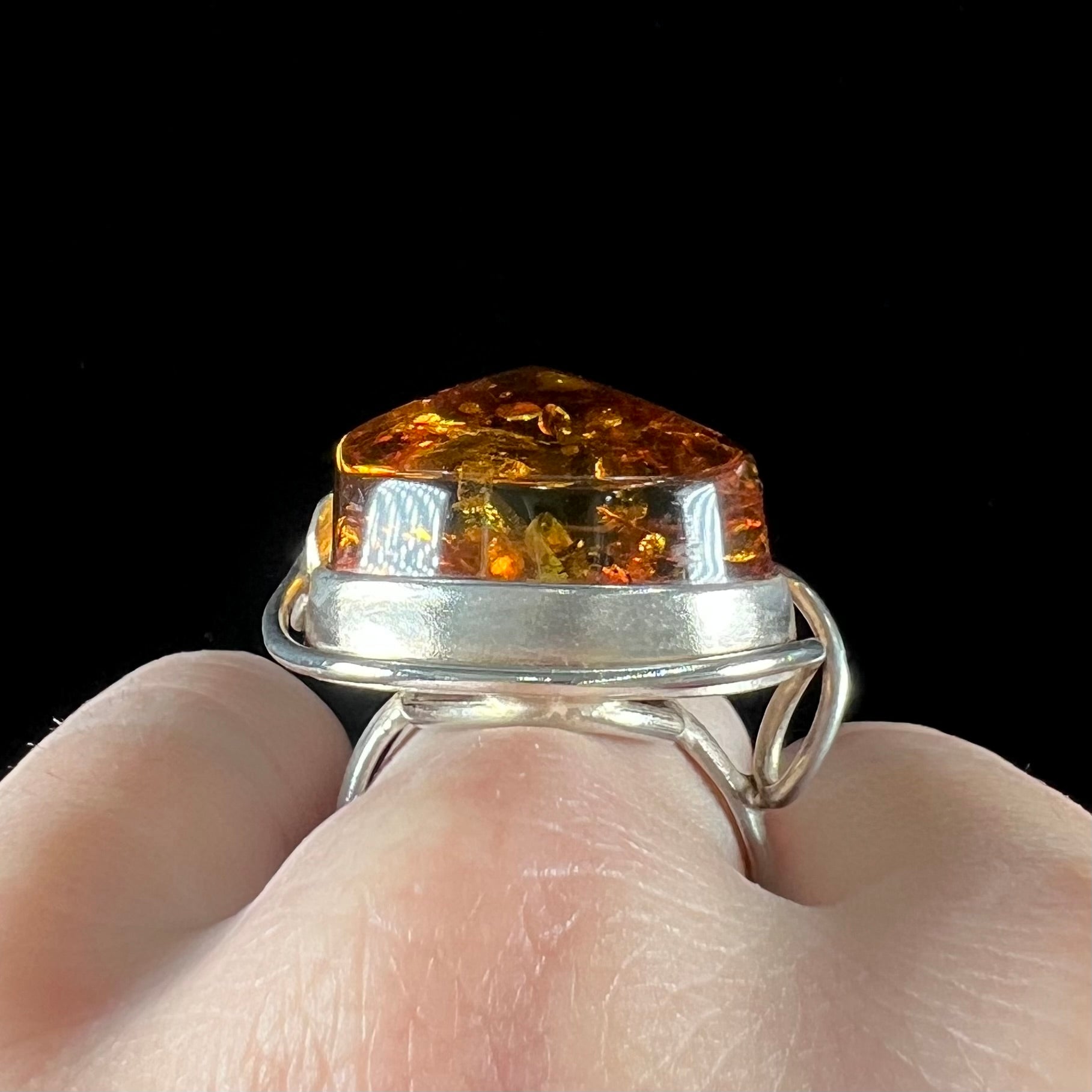 Unisex sterling silver ring set with a large sun-spangled Baltic amber gemstone.