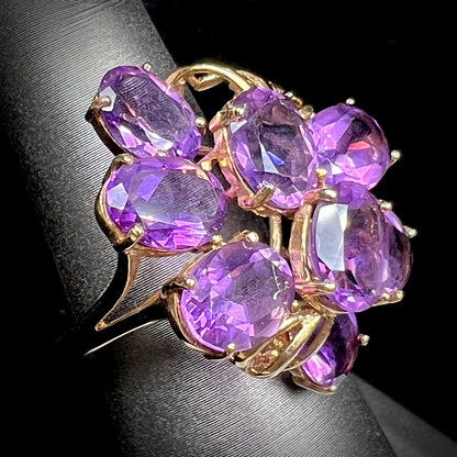 A cluster ring set with eight purple oval cut amethysts in yellow gold.