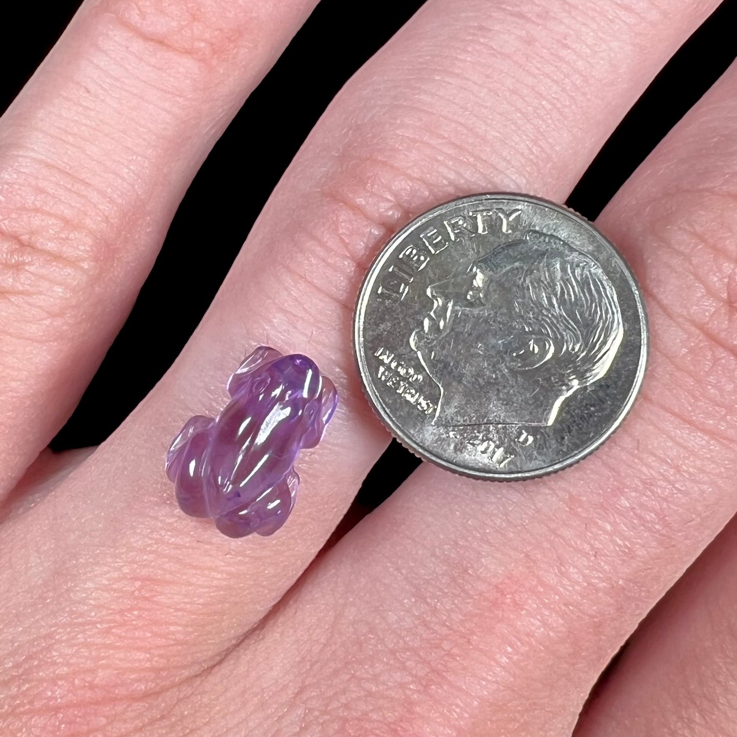 A stone frog carved from purple amethyst crystal.