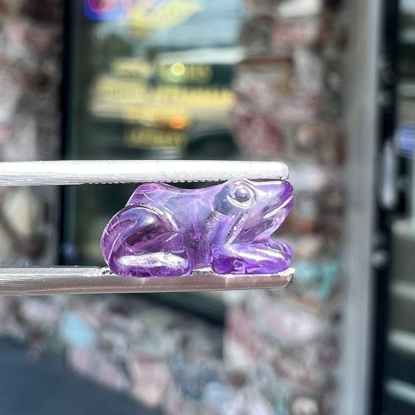 A stone frog carved from purple amethyst crystal.