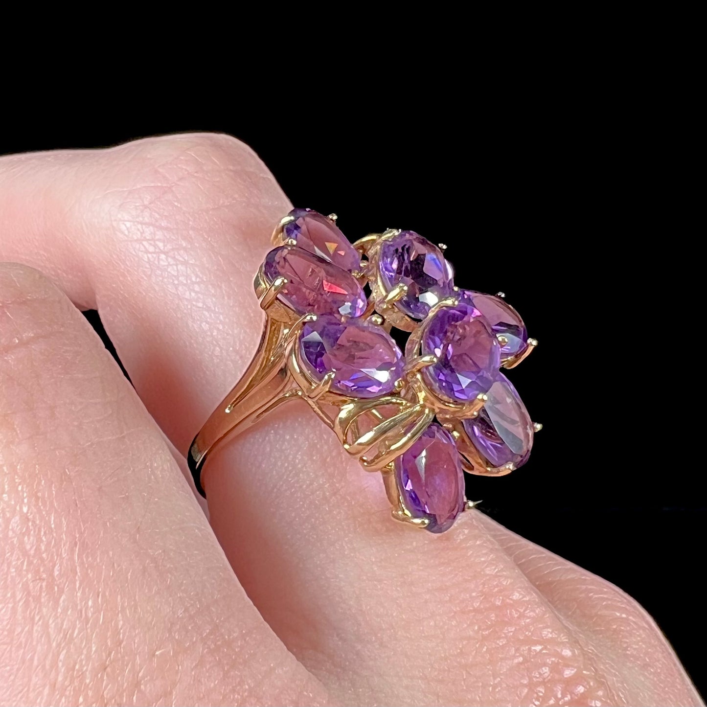 A cluster ring set with eight purple oval cut amethysts in yellow gold.