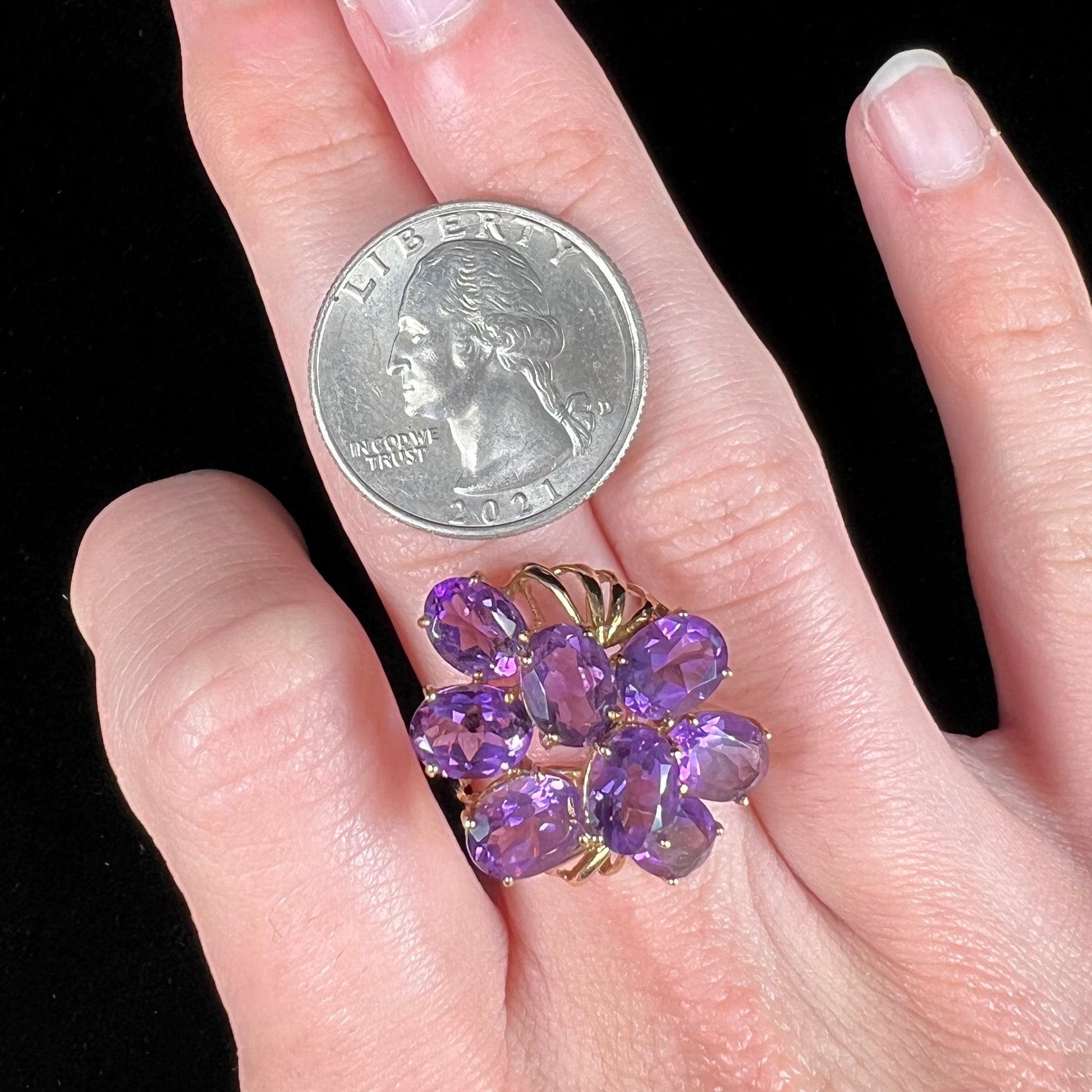 A cluster ring set with eight purple oval cut amethysts in yellow gold.