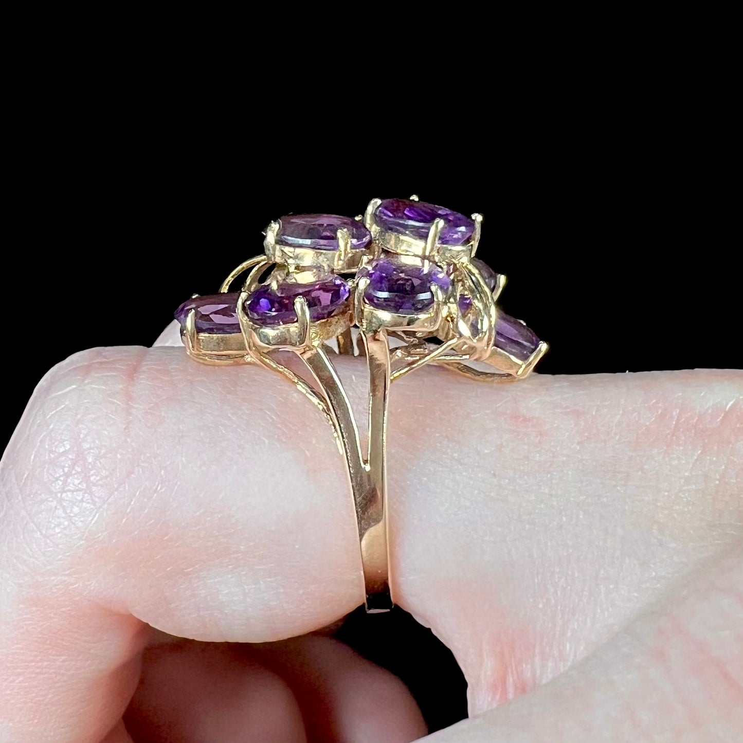 A cluster ring set with eight purple oval cut amethysts in yellow gold.