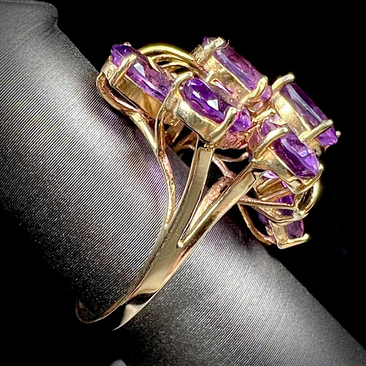 A cluster ring set with eight purple oval cut amethysts in yellow gold.