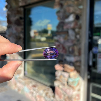 A loose, modified oval step cut amethyst gemstone.  There are light scratches to the table.