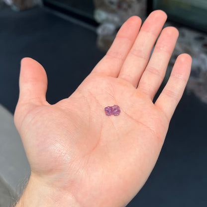 A stone frog carved from purple amethyst crystal.