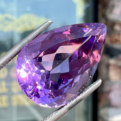 A loose, pear shaped amethyst gemstone.  The stone is a medium purple color.