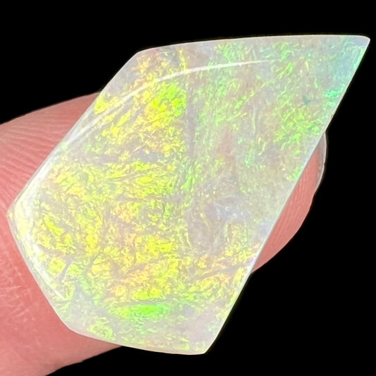 A large, white opal stone from Andamooka, Australia.  The stone shines soft colors of orange, yellow, and green.