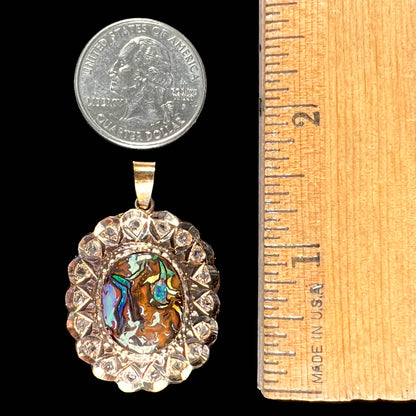 An antique 18 karat yellow gold pendant set with rough diamonds and an oval cut boulder opal from Koroit, Australia.