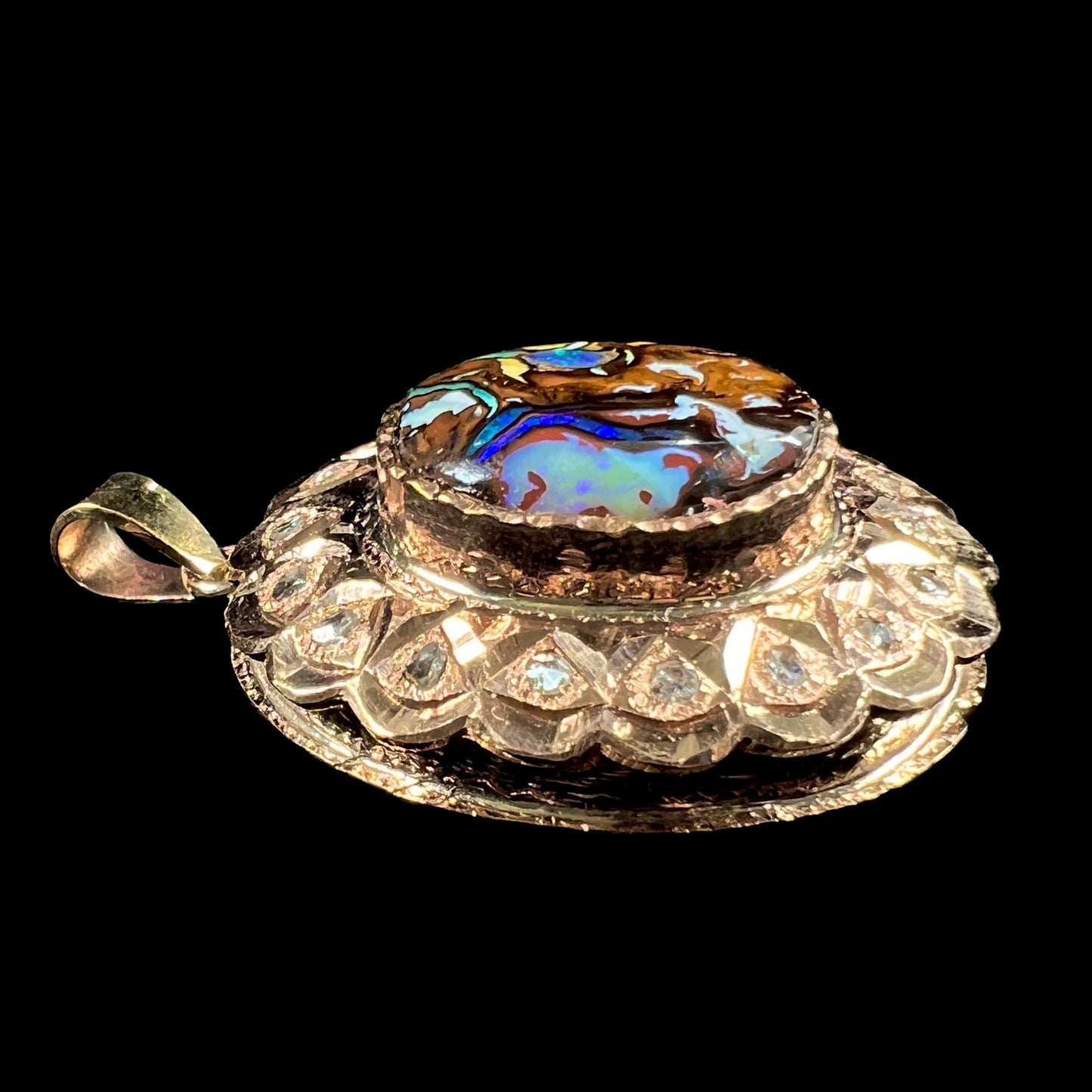 An antique 18 karat yellow gold pendant set with rough diamonds and an oval cut boulder opal from Koroit, Australia.