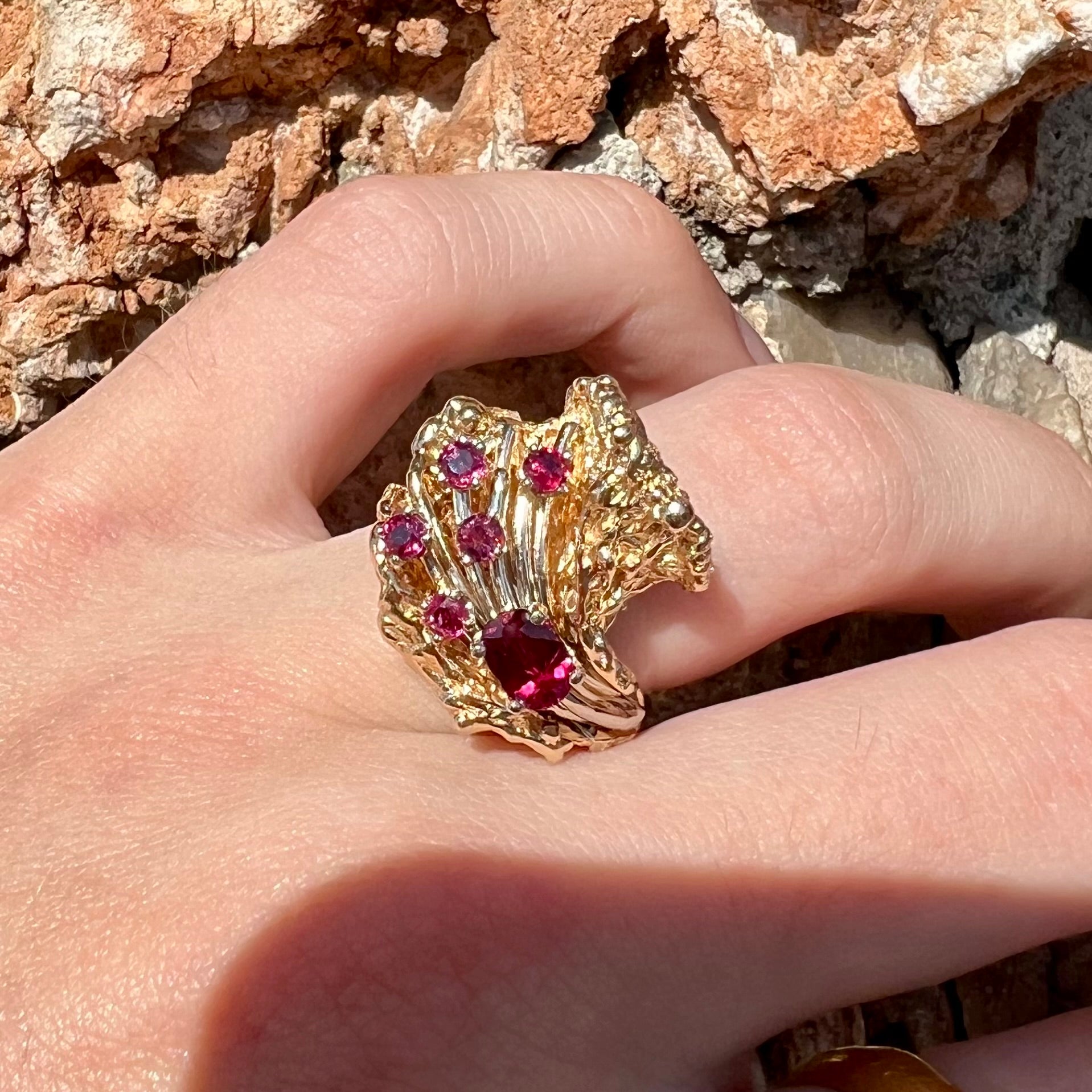 A yellow gold ruby cluster ring from the 1950's.  There is one oval cut ruby and five round cut rubies.