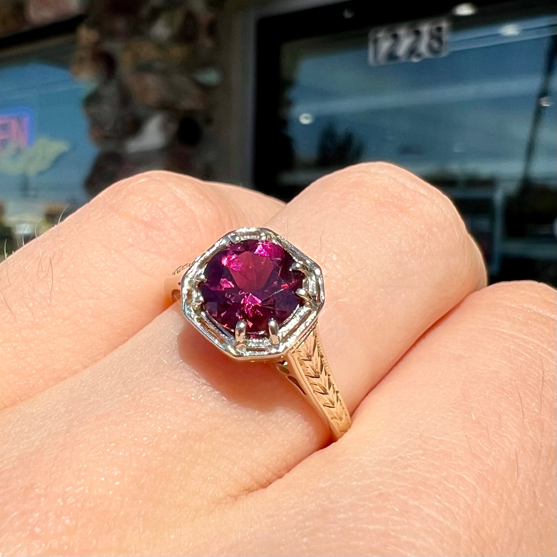 A ladies' yellow gold Art Deco style solitaire ring set with a purple rhodolite garnet gemstone.