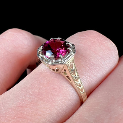 A ladies' yellow gold Art Deco style solitaire ring set with a purple rhodolite garnet gemstone.