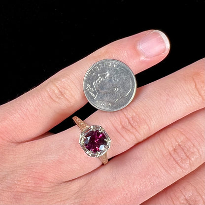 A ladies' yellow gold Art Deco style solitaire ring set with a purple rhodolite garnet gemstone.