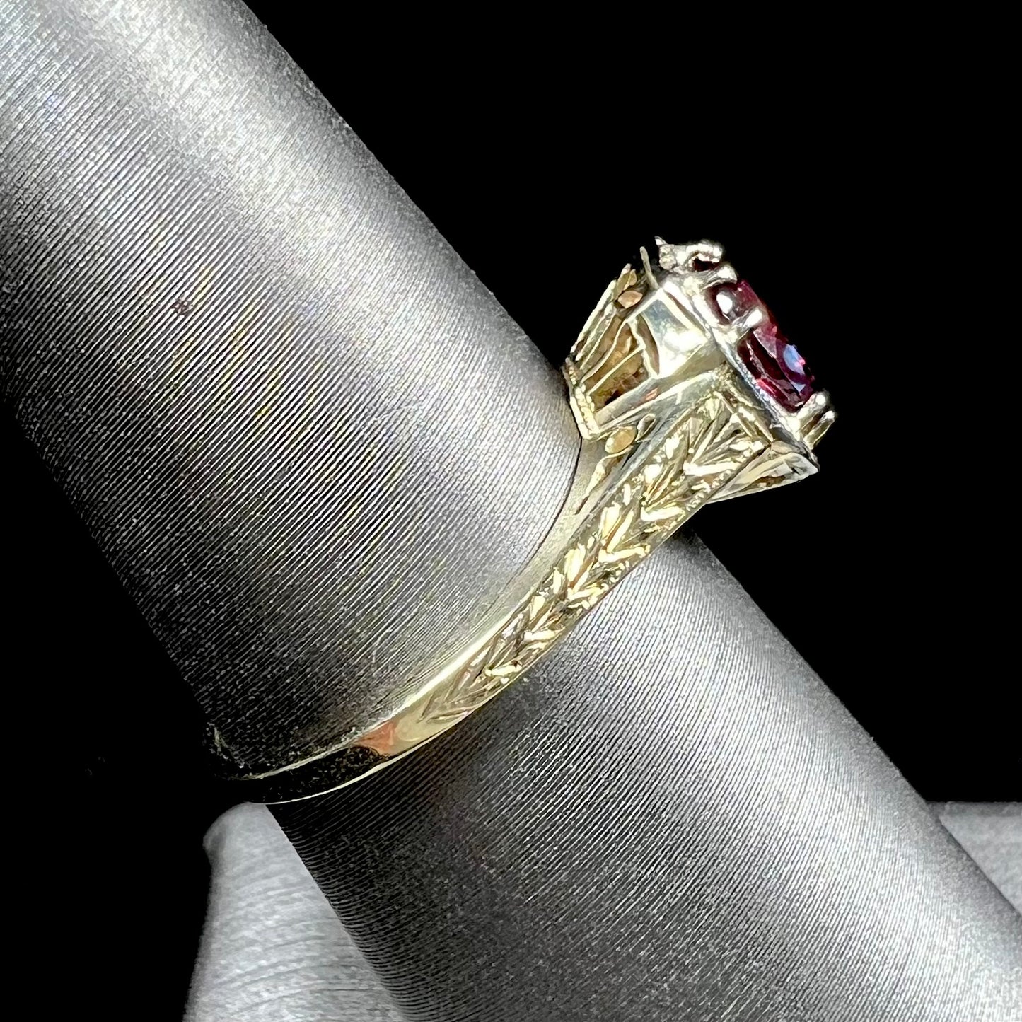 A ladies' yellow gold Art Deco style solitaire ring set with a purple rhodolite garnet gemstone.