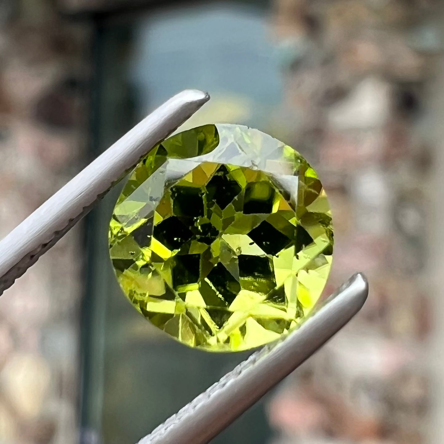 A loose, round brilliant cut peridot gemstone.