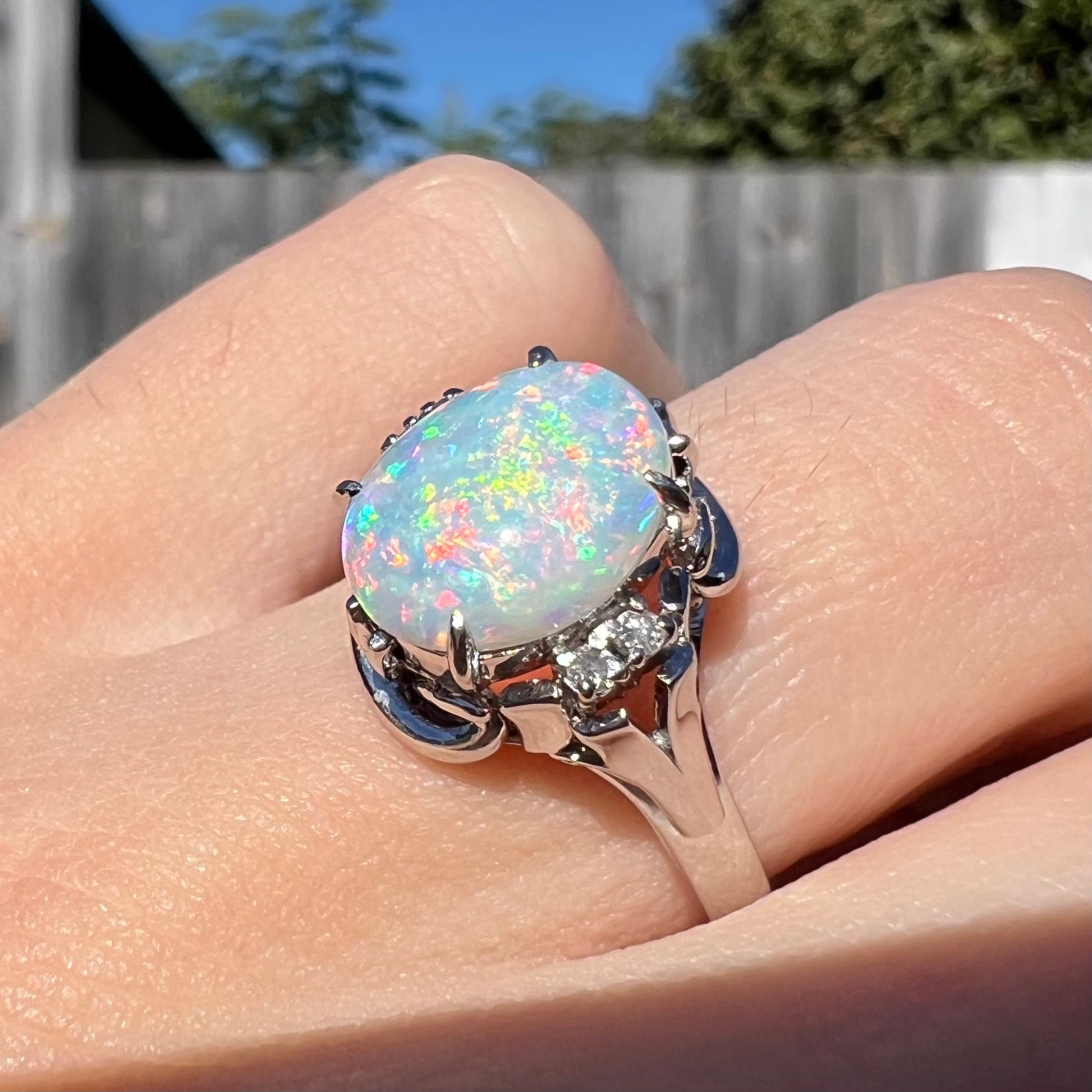 A platinum  and diamond ring prong-set with an Australian opal.  The opal has pink color play.