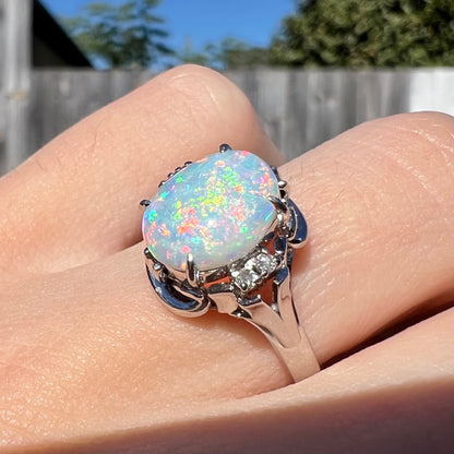 A platinum  and diamond ring prong-set with an Australian opal.  The opal has pink color play.