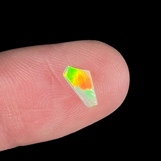 A loose, Australian fire opal chip.  The stone shines red, green, and yellow colors.