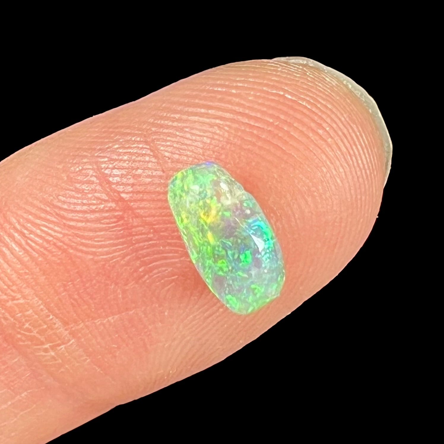 A loose, semi-crystal opal from Australia.  The opal predominantly show green and orange colors.