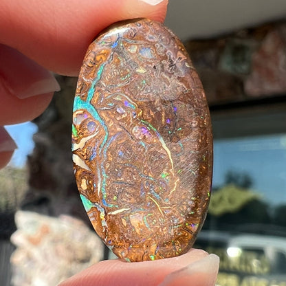 A loose, oval shaped Koroit boulder matrix opal.  The stone has patterns that resembles a rose.