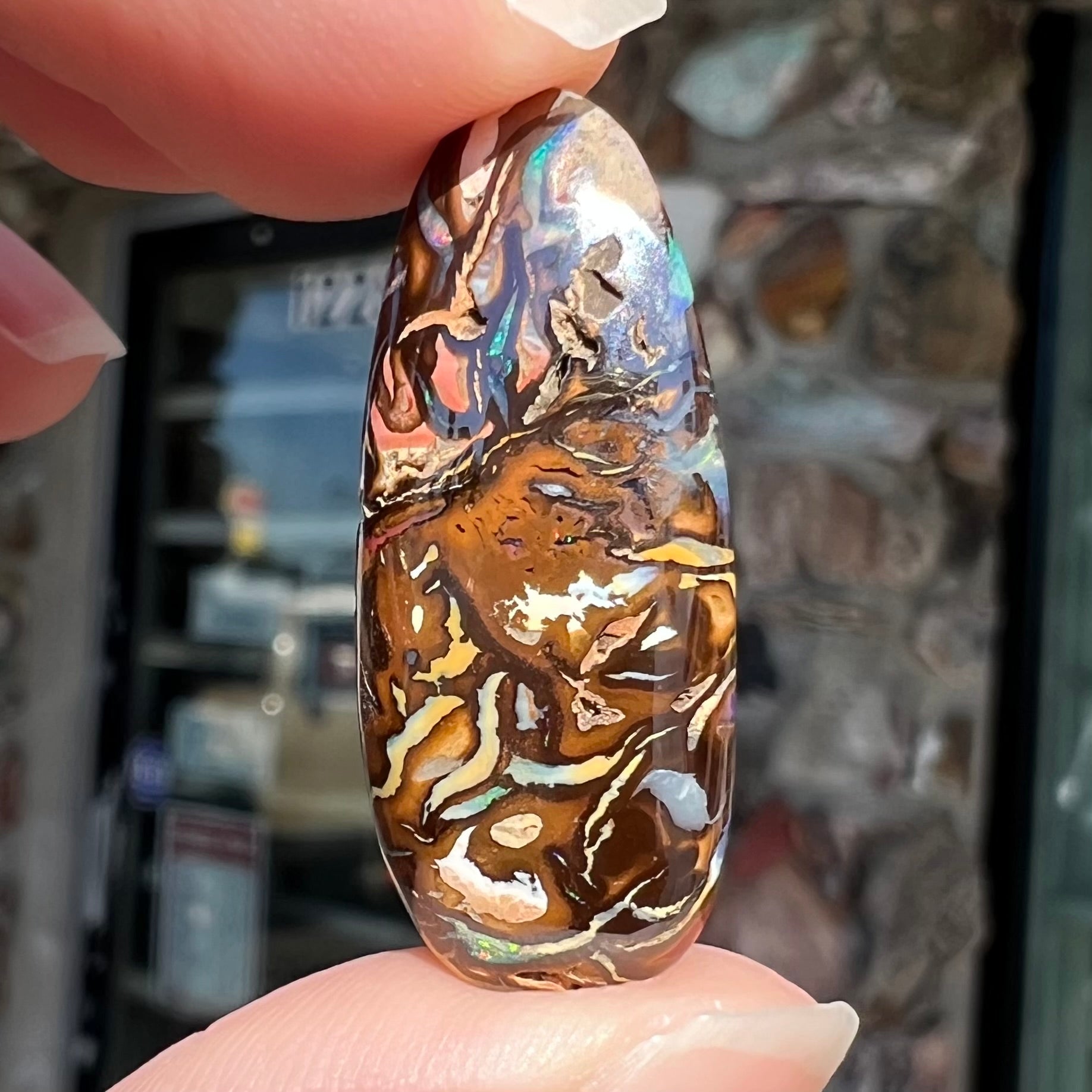 A polished, pear shaped boulder opal stone from Koroit, Australia. 