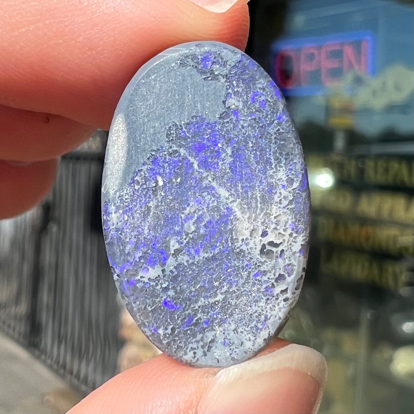 A loose, oval cabochon cut black opal from Lightning Ridge, Australia that weighs 13.09 carats.  The opal is blue.