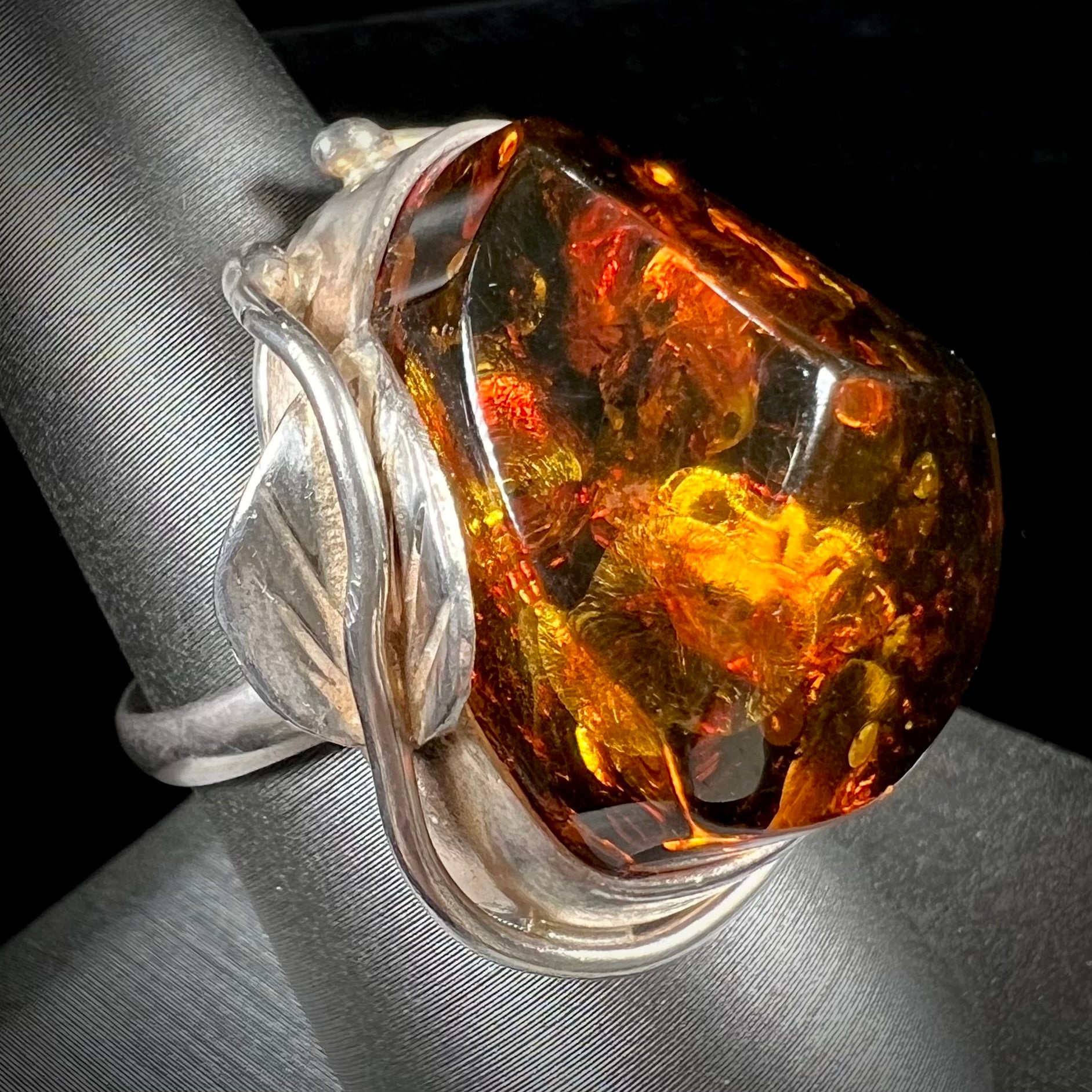 Unisex sterling silver ring set with a large sun-spangled Baltic amber gemstone.