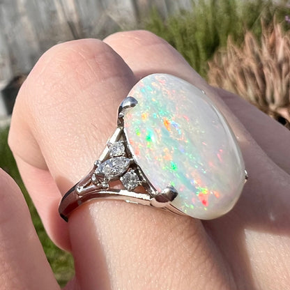 A platinum statement ring mounted with a 7.97ct Coober Pedy opal and marquise cut diamond accents.