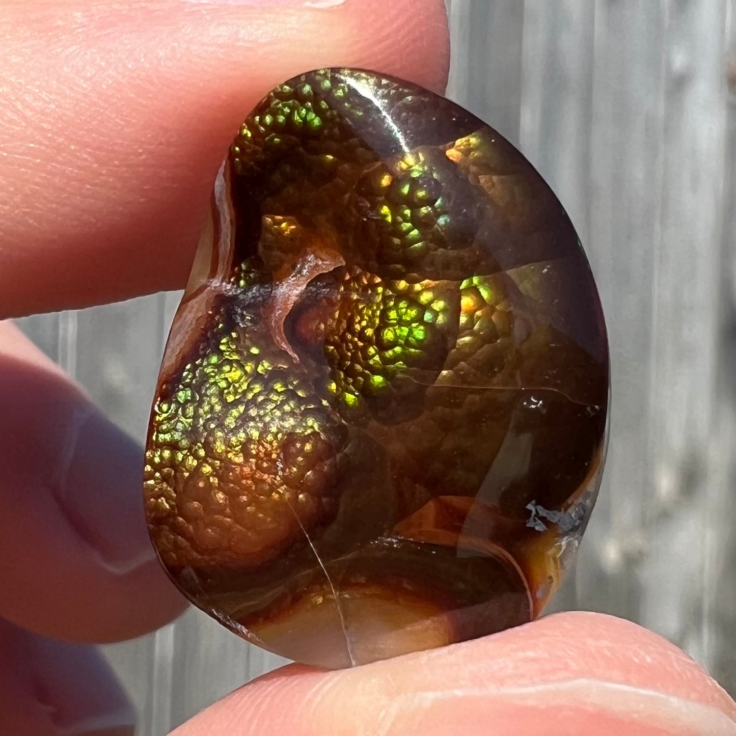 A large Mexican fire agate cabochon.  The stone has a bubbly green pattern.