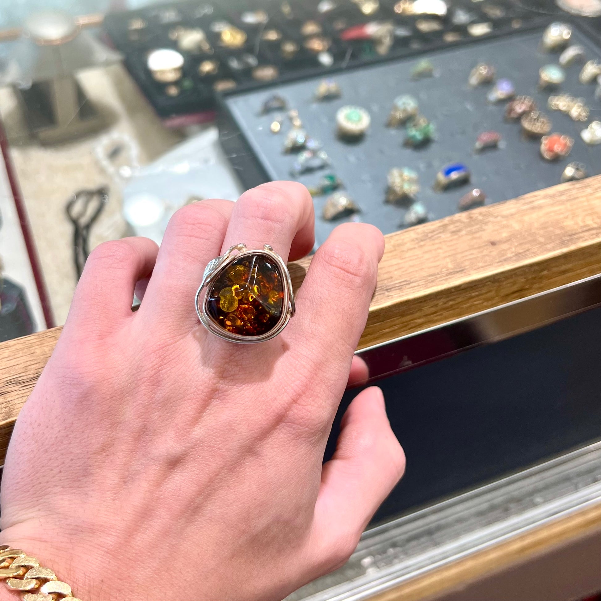 Unisex sterling silver ring set with a large sun-spangled Baltic amber gemstone.