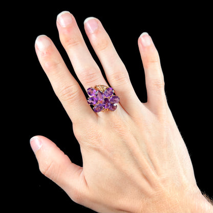 A cluster ring set with eight purple oval cut amethysts in yellow gold.