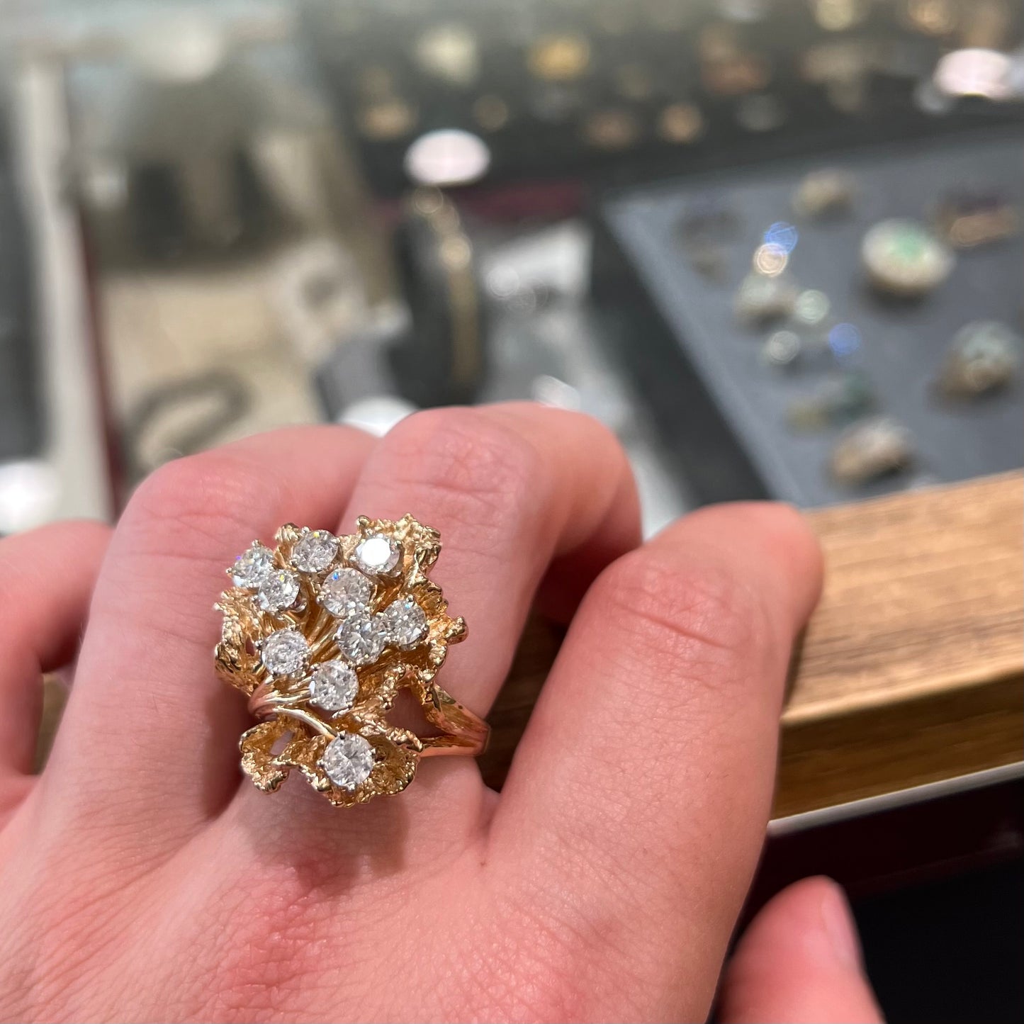 A ladies' 1950's style yellow gold and diamond cluster ring.  The ring is shaped like a leaf with 10 round diamonds set in it.