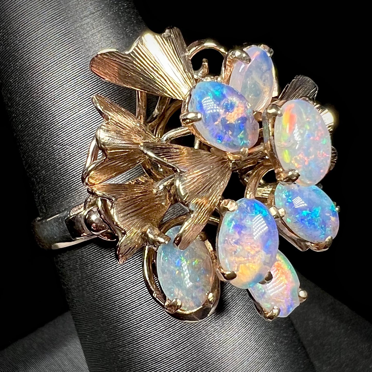 A ladies' vintage, modernist style opal cluster ring in yellow gold.  The ring is tall with a high profile.